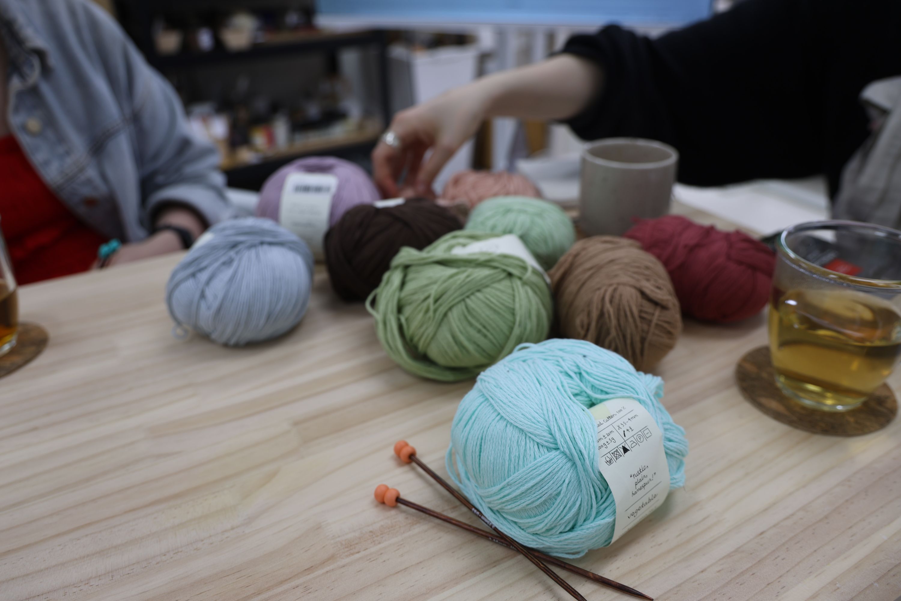Colorful yarn balls and knitting needles on the studio table