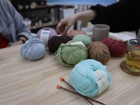 Colorful yarn balls and knitting needles on the studio table