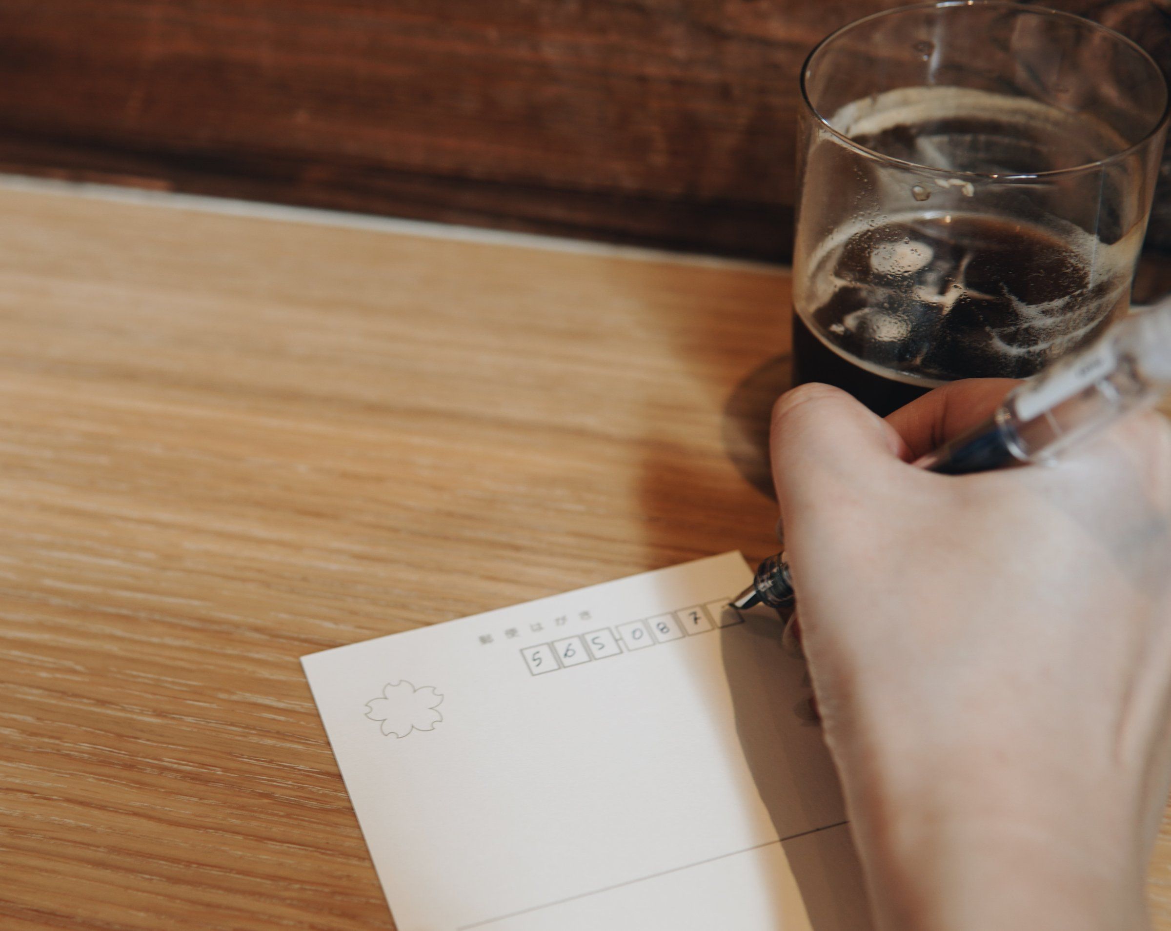 Writing an address on a postcard over coffee