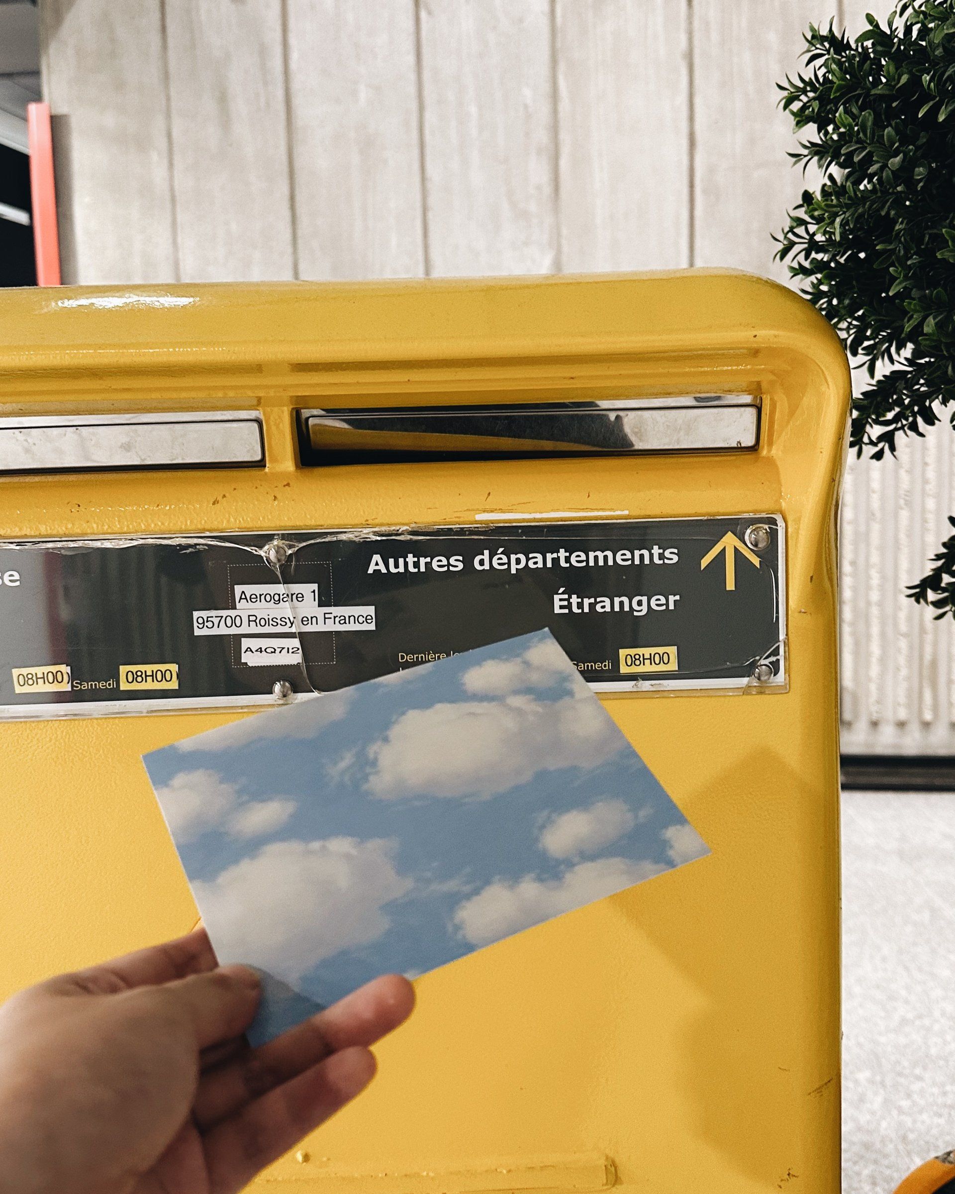 Sending a cloud postcard through a yellow mailbox