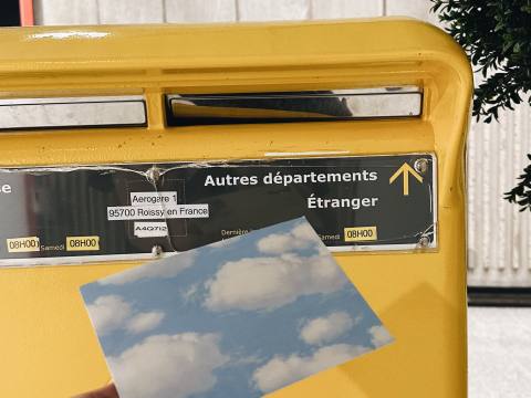 Sending a cloud postcard through a yellow mailbox
