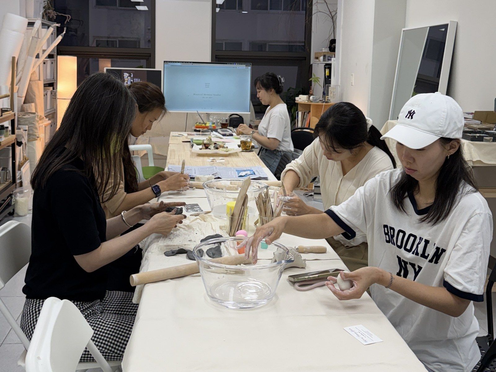Participants shaping clay together around the table — Material Lab × AI Archiving, July 15, 2026