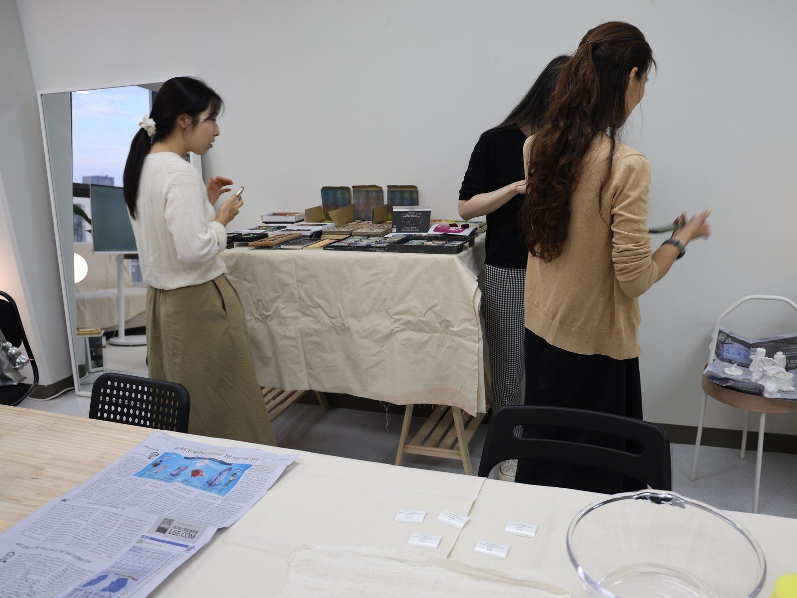 Participants browsing books and materials at a side table — Material Lab × AI Archiving, July 15, 2026