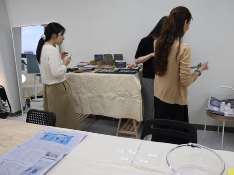 Participants browsing books and materials at a side table — Material Lab × AI Archiving, July 15, 2026