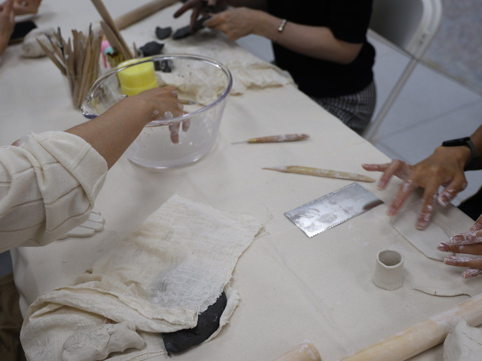 Hands mixing plaster in a bowl at the working table — Material Lab × AI Archiving, July 15, 2026