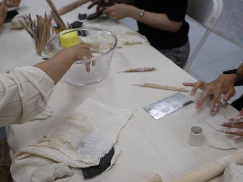 Hands mixing plaster in a bowl at the working table — Material Lab × AI Archiving, July 15, 2026