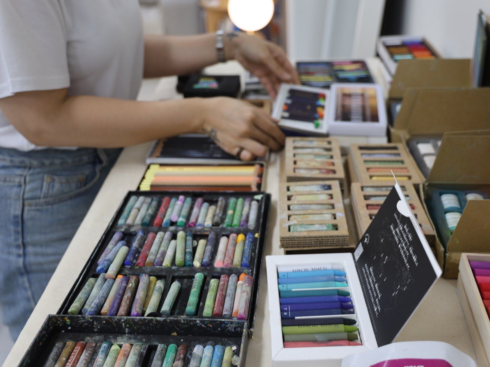 Hands selecting pastel colors from open pastel sets — Material Lab × AI Archiving, July 15, 2026