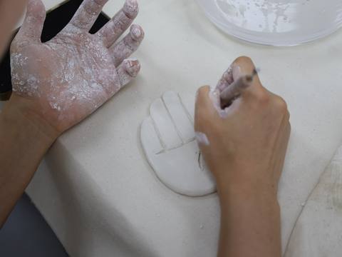 Hands kneading a small piece of white clay — Material Lab × AI Archiving, July 15, 2026