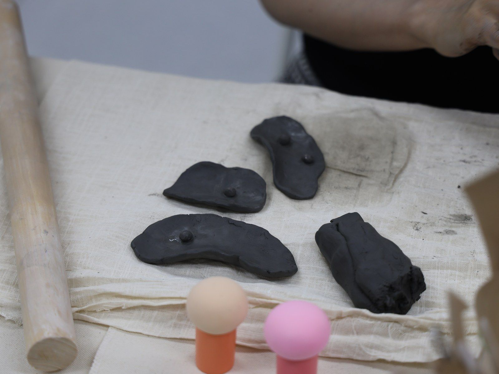 Finished dark clay pieces beside colorful ball-shaped tools — Material Lab × AI Archiving, July 15, 2026