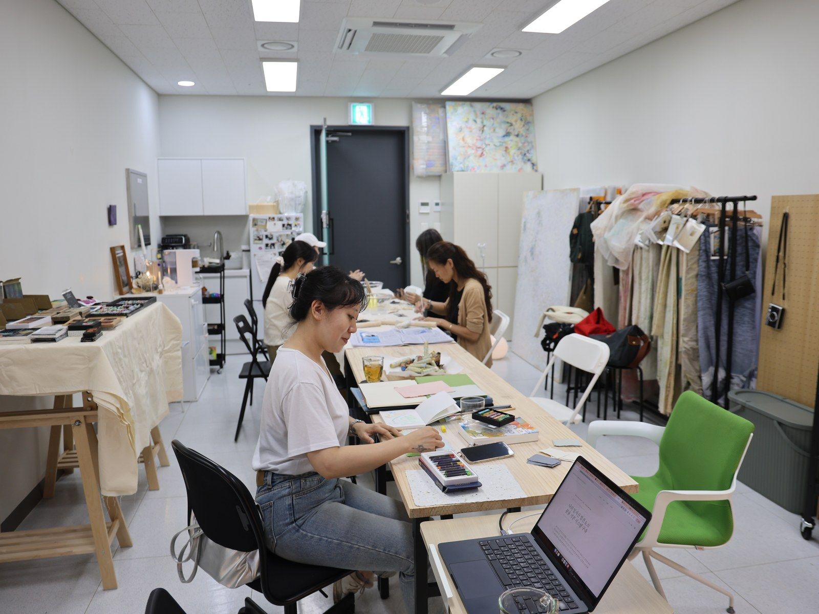 Participants working at long tables with a laptop open — Material Lab × AI Archiving, July 15, 2026