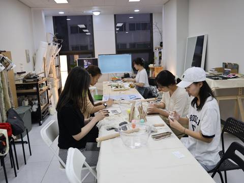 Participants seated side by side working at the long table — Material Lab × AI Archiving, July 15, 2026