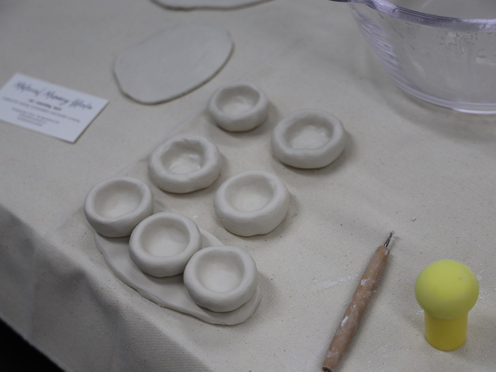 Small clay dishes shaped in a row on cloth — Material Lab × AI Archiving, July 15, 2026