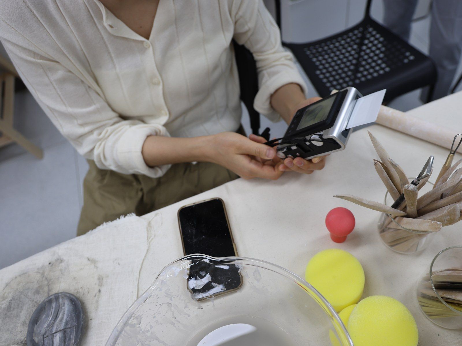 Hands holding a small vintage-style camera on the table — Material Lab × AI Archiving, July 15, 2026