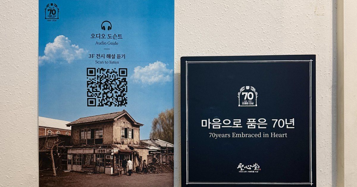 Exhibition wall — the QR sign linking to the audio docent, beside the exhibition title plaque